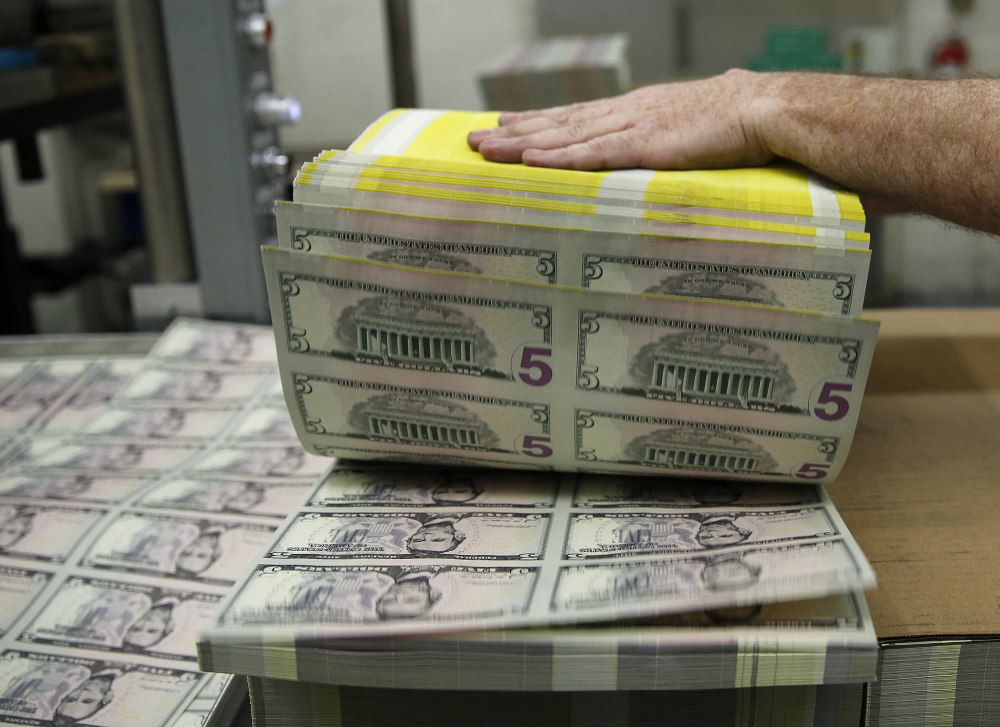 Sheets of U.S. five-dollar bills are printed at the Bureau of Engraving and Printing in Washington in March 2015.  | REUTERS