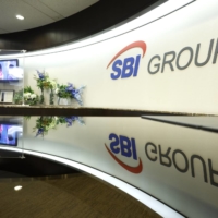 The group logo of SBI Holdings Inc. is displayed in a reception area at the company\'s head office in Tokyo. | BLOOMBERG