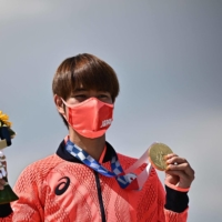 Gold medal-winning skateboarder Yuto Horigome poses on the podium at Ariake Sports Park in Tokyo in July. The kanji of the year referenced the number of gold medals won by Japan\'s athletes at the 2020 Tokyo Olympics and Paralympics. | AFP-JIJI