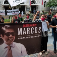 Members of the opposition Akbayan Partylist party gather outside the Commission on Elections in Manila on Dec. 2 where they filed a petition to disqualify Ferdinand “Bongbong” Marcos Jr. from the 2022 national election. | REUTERS