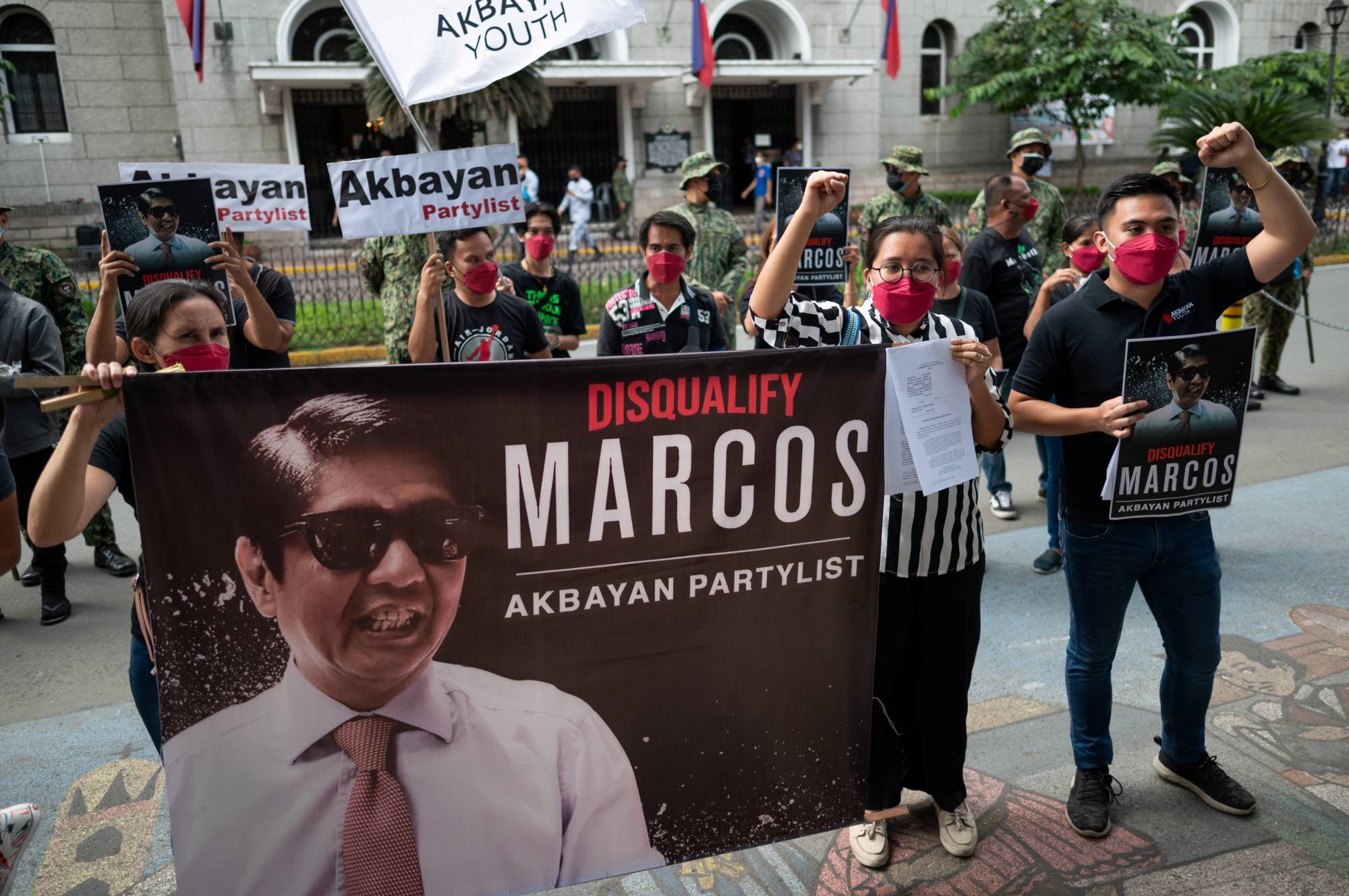 Members of the opposition Akbayan Partylist party gather outside the Commission on Elections in Manila on Dec. 2 where they filed a petition to disqualify Ferdinand “Bongbong” Marcos Jr. from the 2022 national election. | REUTERS
