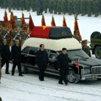 Kim Jong Un and other top North Korean officials walk beside a convoy carrying the body of his father, Kim Jong Il, in Pyongyang on Dec. 28, 2011. | KCNA / VIA AFP-JIJI