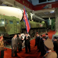 North Korean leader Kim Jong Un speaks to officials next to military weapons and vehicles on display, including the country\'s intercontinental ballistic missiles, at the Defense Development Exhibition in Pyongyang in this undated photo released on Oct. 12. | KCNA / VIA REUTERS