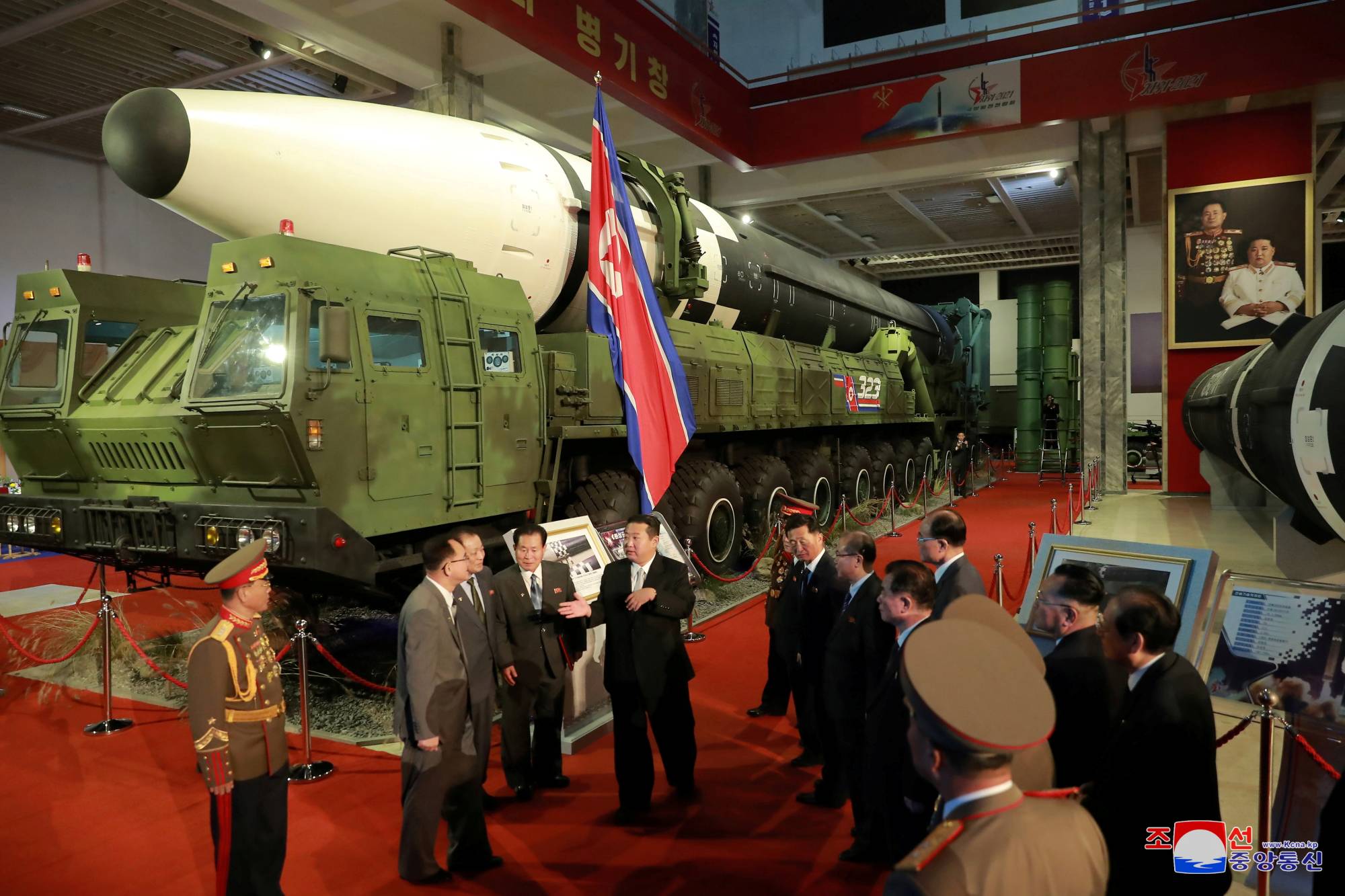 North Korean leader Kim Jong Un speaks to officials next to military weapons and vehicles on display, including the country's intercontinental ballistic missiles, at the Defense Development Exhibition in Pyongyang in this undated photo released on Oct. 12. | KCNA / via REUTERS