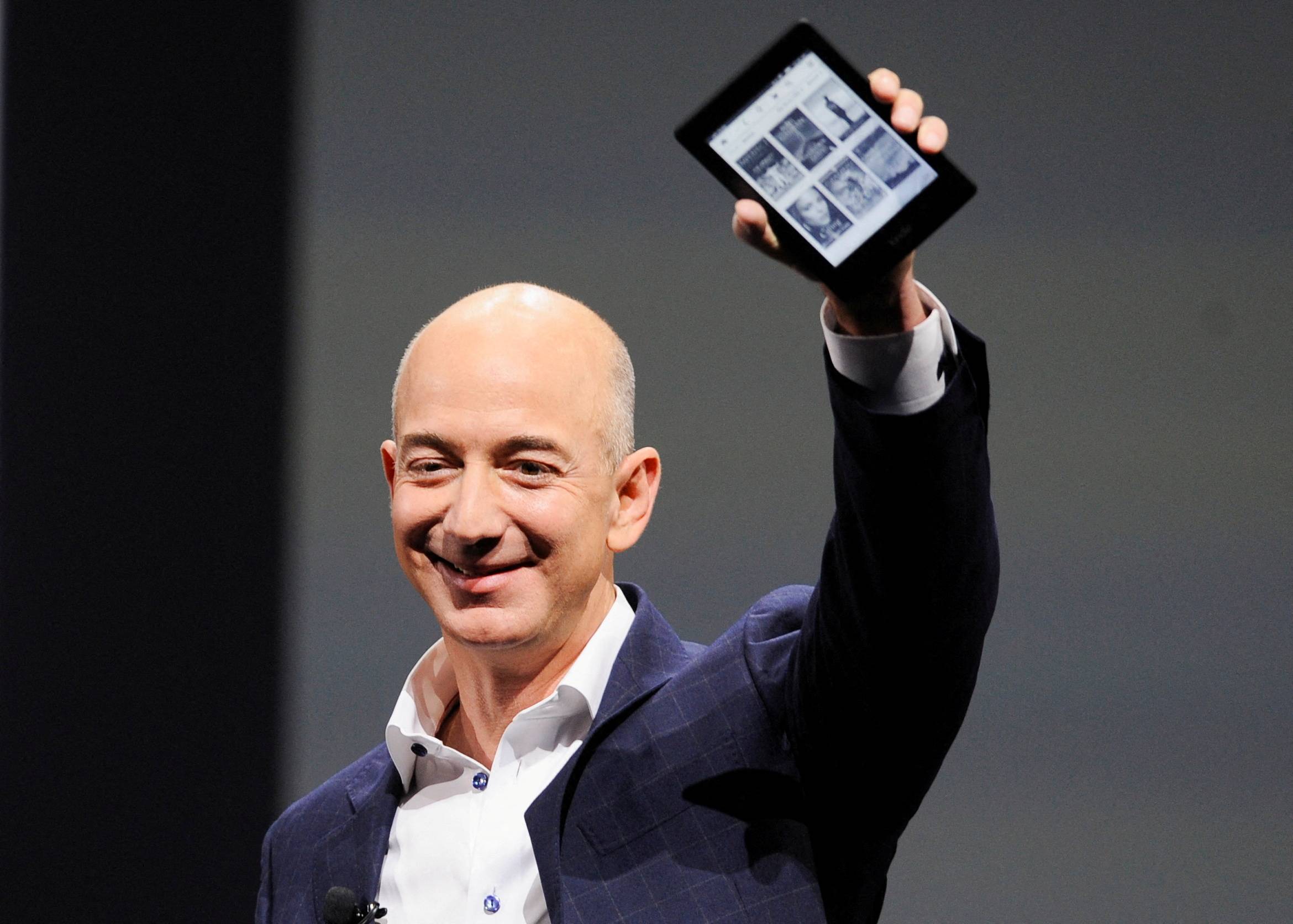 Amazon CEO Jeff Bezos holds up a Kindle Paperwhite during an event in Santa Monica, California, in September 2012. | REUTERS