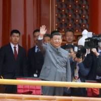 Chinese leader Xi Jinping waves next to Premier Li Keqiang (far left) and former President Hu Jintao (far right) at the end of the event marking the 100th founding anniversary of the Communist Party of China in Beijing\'s Tiananmen Square on July 1. | REUTERS