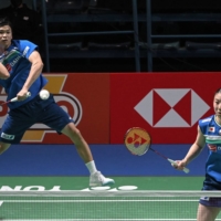 Yuta Watanabe and Arisa Higashino hit compete during the mixed doubles semifinal at the badminton world championships on Saturday in Huelva. | AFP-JIJI