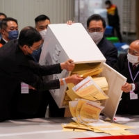 The chairman of Electoral Affairs Commission, Barnabas Fung Wah, and other members of EAC open the ballot box for the Legislative Council election at a vote counting center, in Hong Kong on Dec. 19, 2021.  | REUTERS