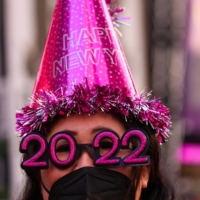 Teresa Hui, 40, of Brooklyn, wears 2022 numeral glasses and a face mask in Times Square ahead of New Year\'s Eve celebrations as the omicron coronavirus variant continues to spread in Manhattan, New York City on Dec. 20, 2021. |  REUTERS