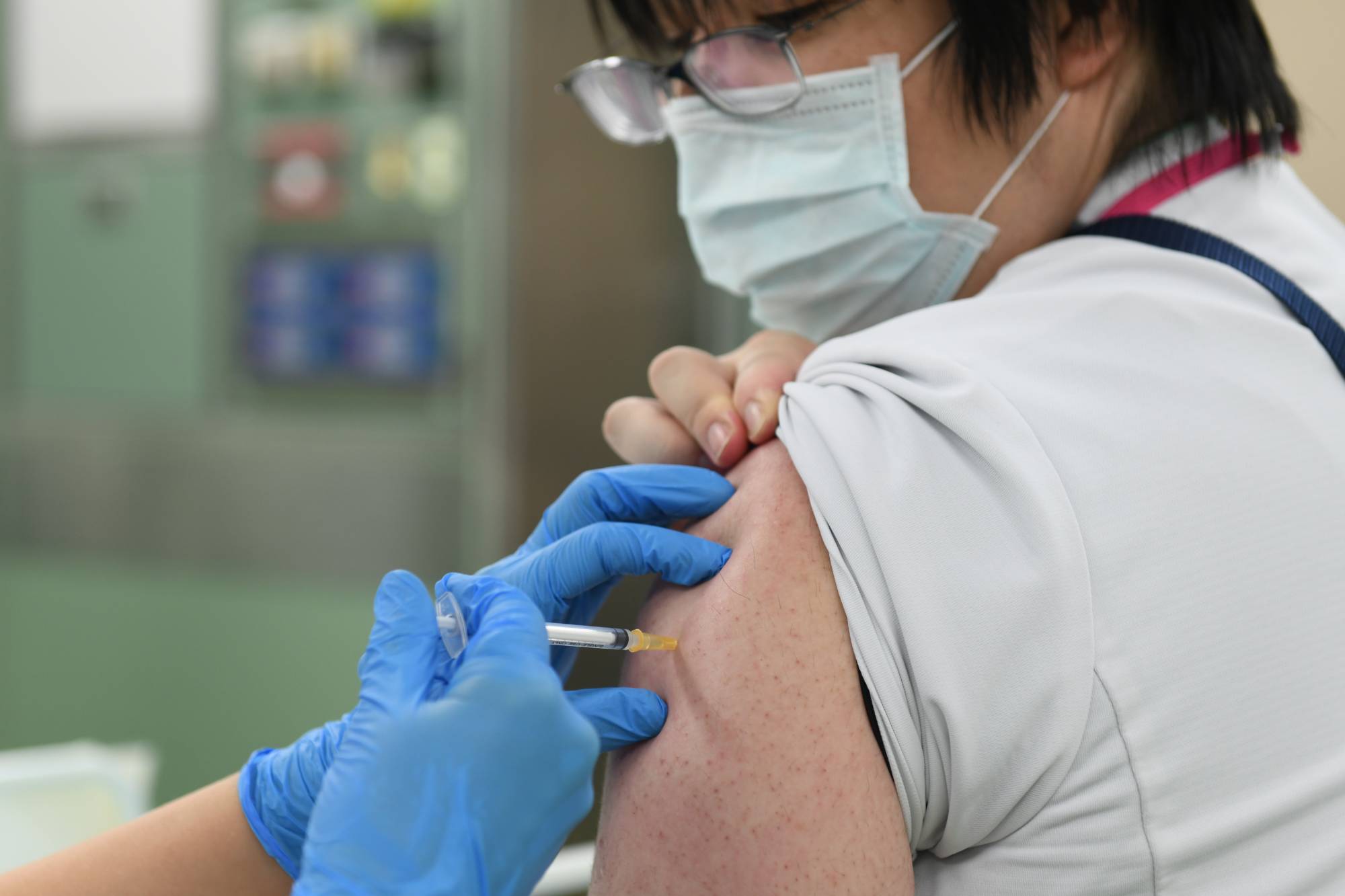 A nurse receives a booster shot of the Pfizer-BioNTech COVID-19 vaccine at Chiba University Hospital. | BLOOMBERG