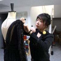 Zhang Yifan works on an outfit she designed for her sister, figure skater Zhang Yixuan, in Beijing on Dec. 7. | REUTERS
