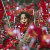 Supporters of Myanmar opposition leader Aung San Suu Kyi hold posters bearing her image in 2015. Myanmar’s military government is planning to hold fresh elections in August 2023. | AFP-JIJI