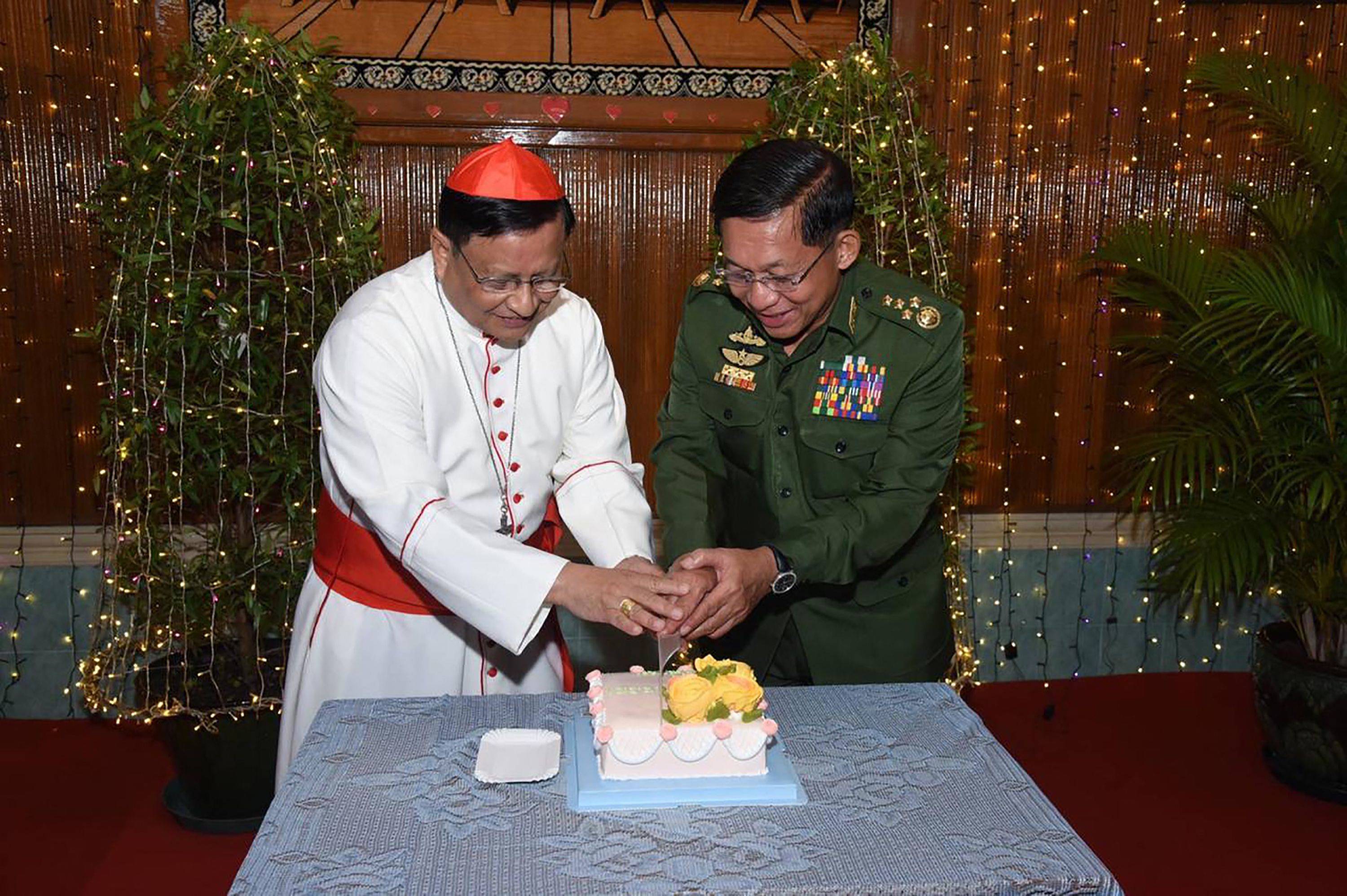 Myanmar's top Catholic cardinal, Charles Bo, cuts a Christmas cake with Myanmar's armed forces chief, Min Aung Hlaing, in Yangon on Thursday. | MYANMAR MILITARY INFORMATION TEAM / via AFP-JIJI
