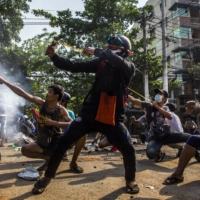 Protesters in Yangon, Myanmar, on March 28 use homemade weapons in a clash with security forces.  | THE NEW YORK TIMES