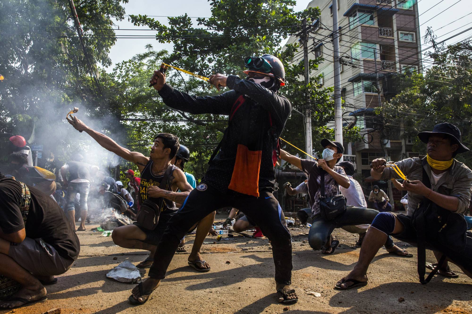 Protesters in Yangon, Myanmar, on March 28 use homemade weapons in a clash with security forces. | The New York Times