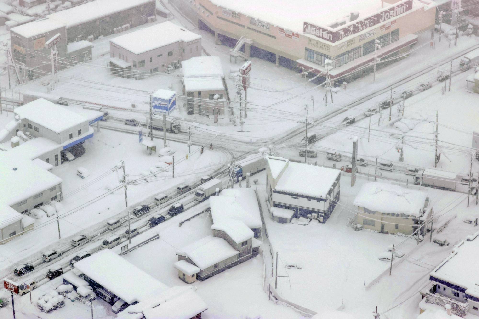 Vehicles stuck on a road due to heavy snow in Hikone, Shiga Prefecture, on Monday | KYODO