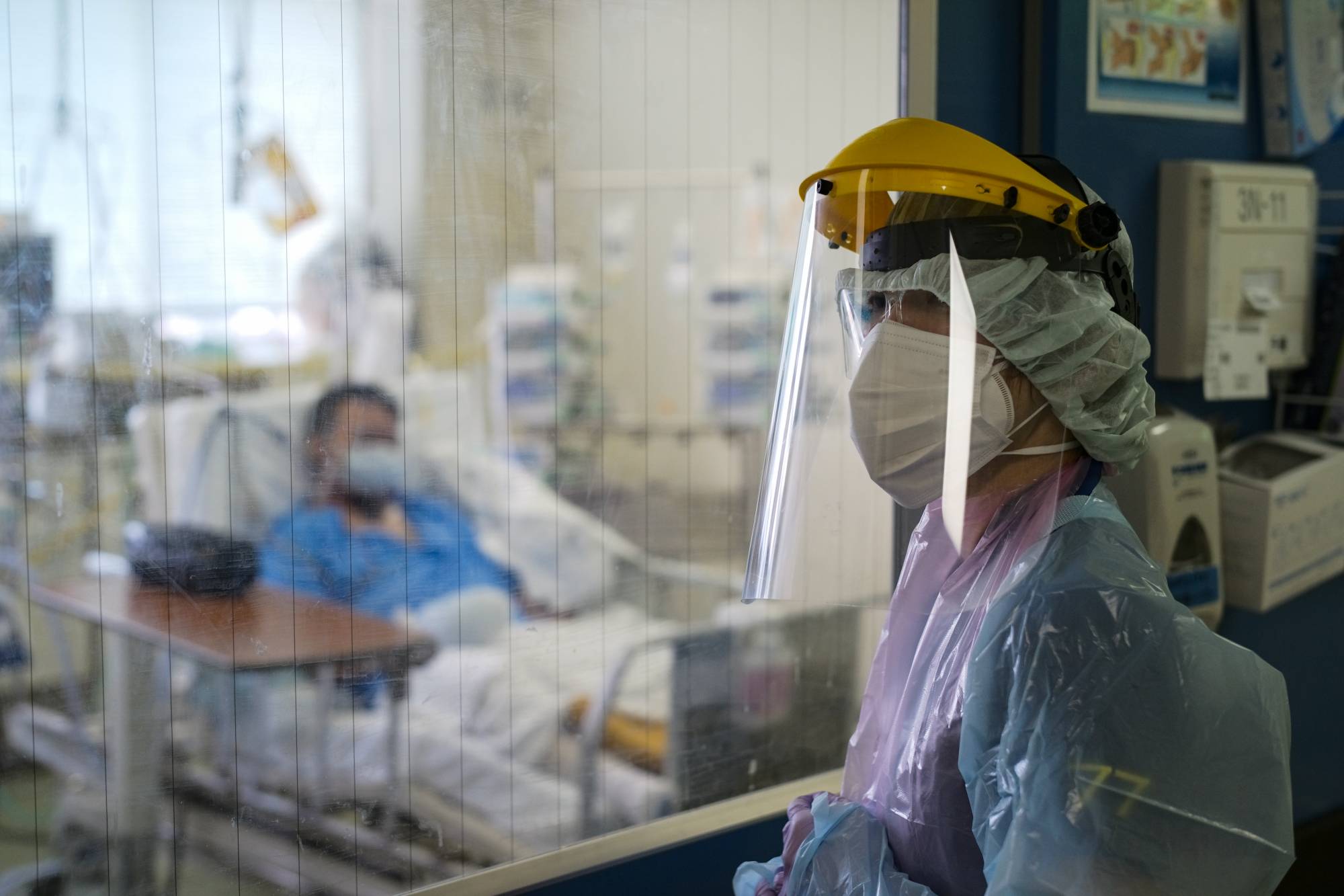 Junko Yamaguchi, deputy director of Itabashi Hospital’s Division of Emergency and Critical Care Medicine, stands outside the room of a patient with COVID-19. | RYUSEI TAKAHASHI 