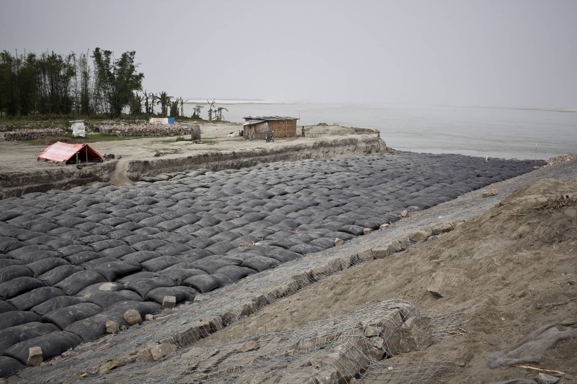 A river embankment construction site at the bank of the Brahmaputra River in Salmora, India in 2013. The river, a critical laboratory in climate studies, has been eroding the island of Majuli in Assam for decades. | .Enrico Fabian / The New York Times