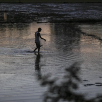 A fisherman holds a fishing net in a village of Nalbari district, Assam, India, in 2019. The Assam region has experienced severe erosion and flooding in the past decade.  | BLOOMBERG