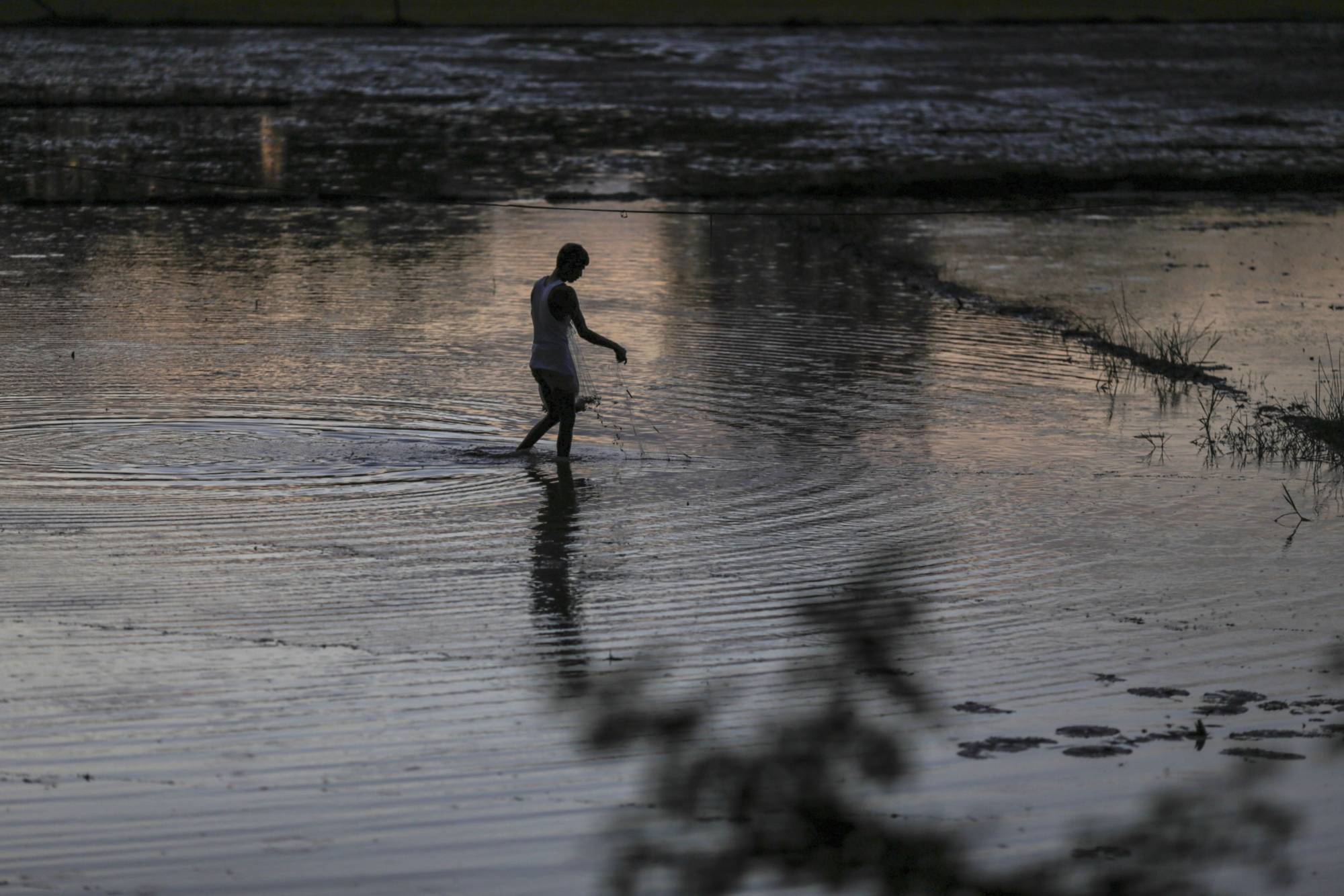 A fisherman holds a fishing net in a village of Nalbari district, Assam, India, in 2019. The Assam region has experienced severe erosion and flooding in the past decade. | Bloomberg