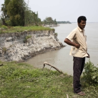 Ganesh Hazarika, who lost his land to erosion, on the bank of the Brahmaputra River in Salmora, India, in April 2013. The river, a critical laboratory in climate studies, is fast eroding the island of Majuli in Assam that it has encircled and sustained for ages.  | ENRICO FABIAN / THE NEW YORK TIMES