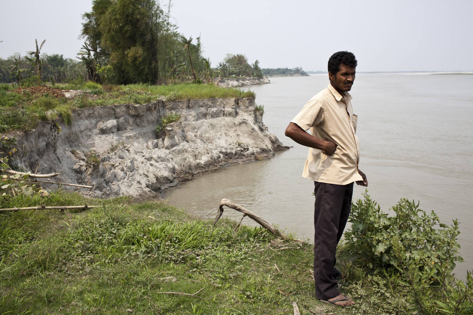 Ganesh Hazarika, who lost his land to erosion, on the bank of the Brahmaputra River in Salmora, India, in April 2013. The river, a critical laboratory in climate studies, is fast eroding the island of Majuli in Assam that it has encircled and sustained for ages.  | ENRICO FABIAN / THE NEW YORK TIMES