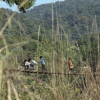 People cross over from Myanmar into Farkawn, India, on a wooden bridge over the Tiau River on Dec. 12. Hundreds of thousands who fled deadly unrest at home confront an uncertain future abroad.  | SAUMYA KHANDELWAL / THE NEW YORK TIMES