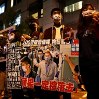 Activists gather outside the Apple Daily building in Taipei on Dec. 14 to rally for press freedom and protest against China\'s national security law. | REUTERS 