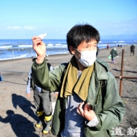 Kenji Shiga, 55, a curator at Ishikari Wind of Dune Museum, discusses an object washed ashore and found on Ishikari Beach. | HOKKAIDO SHIMBUN
