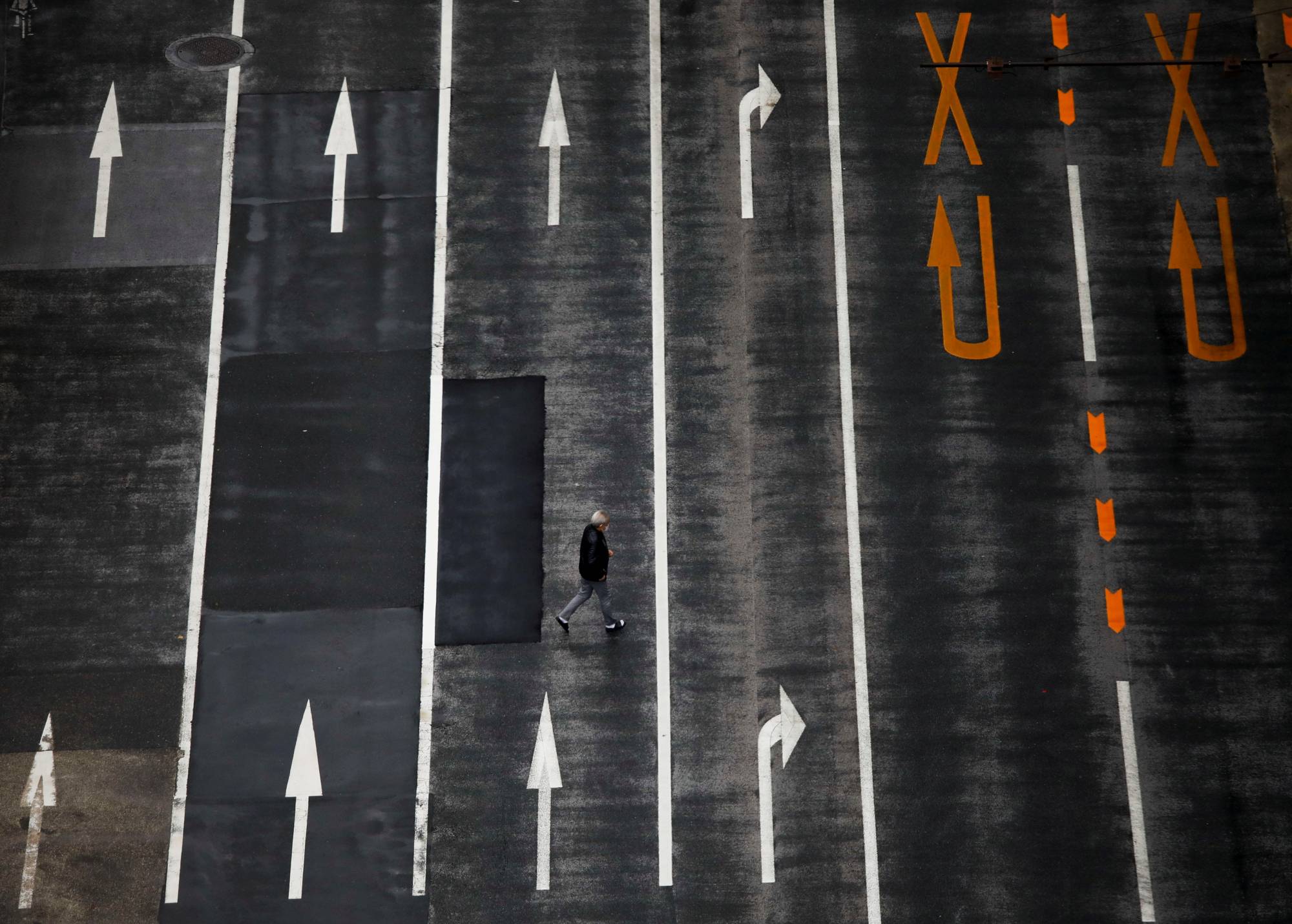 A man walks across an empty road in Tokyo on Dec. 8. | REUTERS