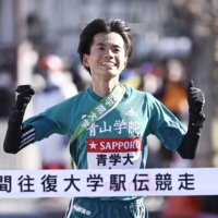 Hiroki Wakabayashi crosses the finish line to give Aoyama Gakuin University the lead on Day 1 of the Tokyo-Hakone collegiate ekiden. | KYODO