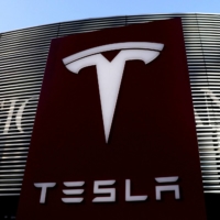 A Tesla logo is seen near a shopping complex in Beijing in January 2021. | REUTERS