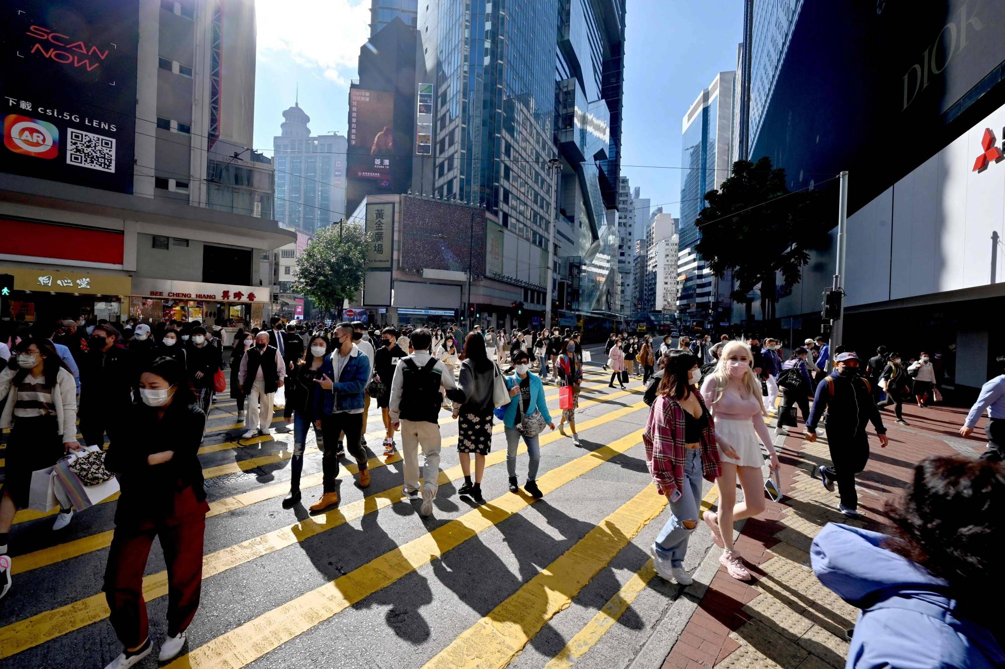 Pedestrians cross a busy intersection in Causeway Bay in Hong Kong on Tuesday. | AFP-JIJI