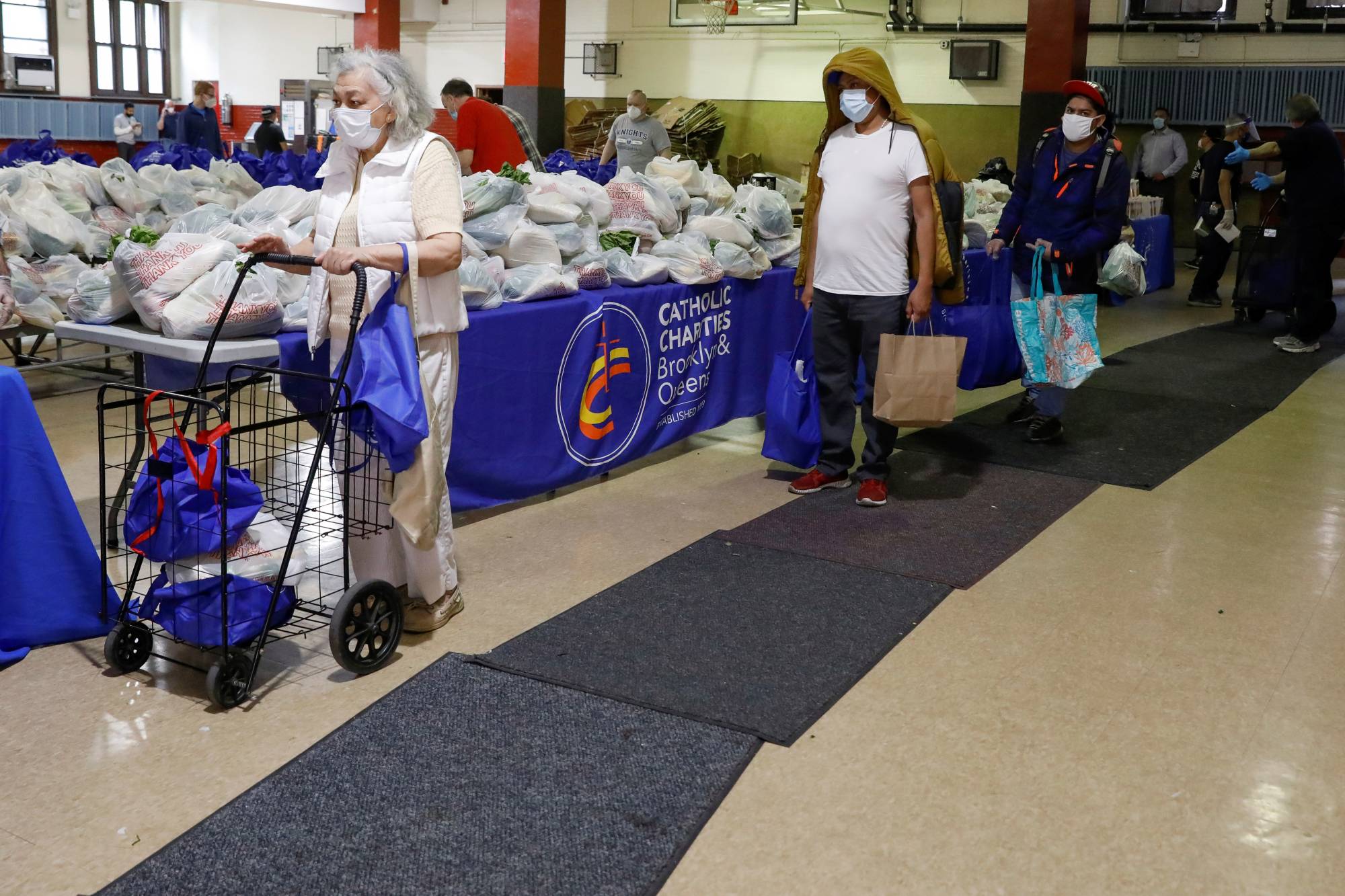 People visit the food bank at St. Bartholomew Church in the Elmhurst section of Queens, New York, in May 2020.  | REUTERS