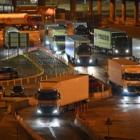 Trucks disembark from ferries at the port of Dover, on the south-east coast of England, on Dec. 31, 2020. One year after the United Kingdom\'s effective exit from the European Union, border controls for goods from the continent will be gradually stepped up on the British side in 2022 — raising concerns among small and medium-size businesses in the country, in particular in the food industry. | AFP-JIJI