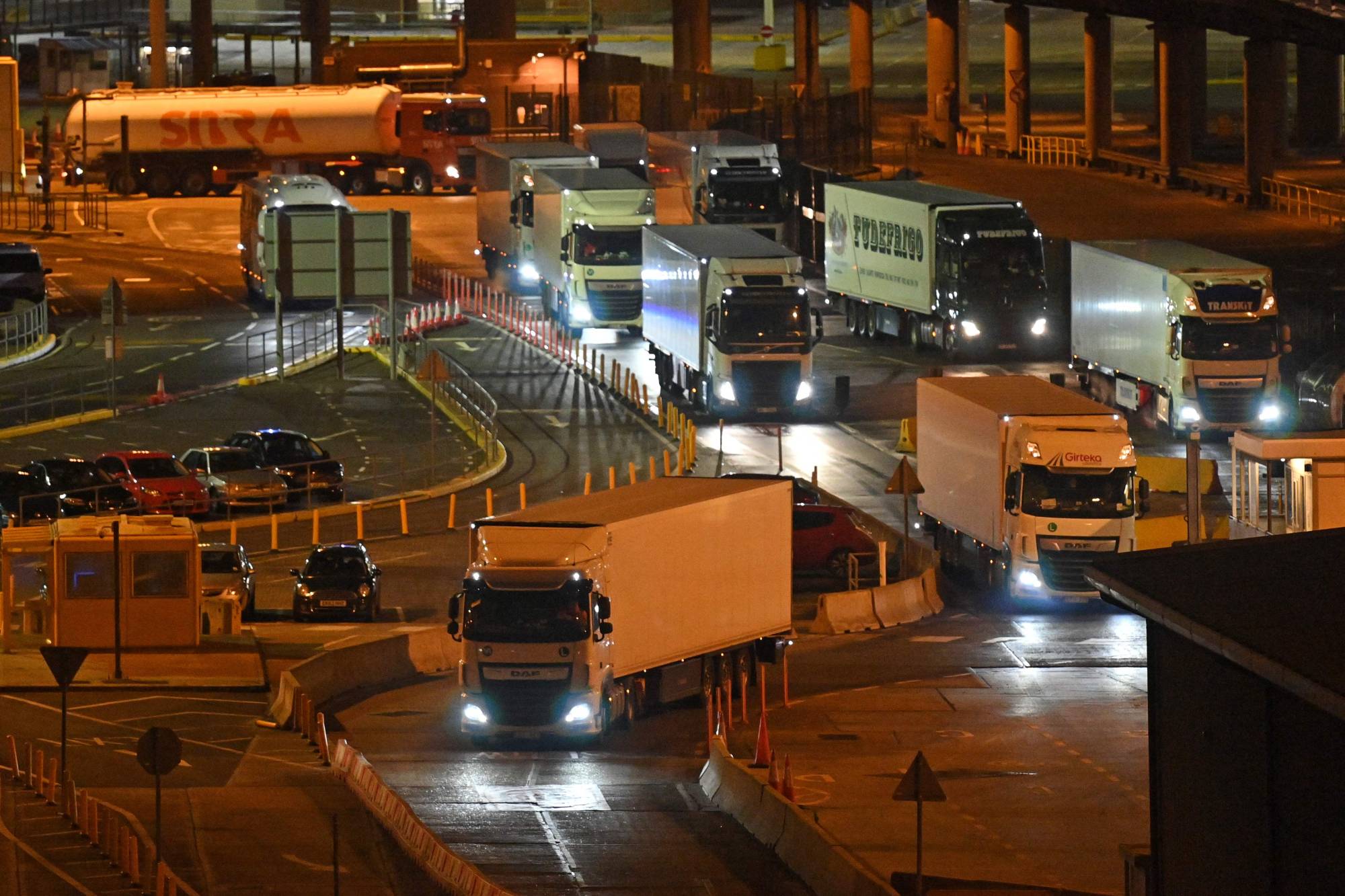 Trucks disembark from ferries at the port of Dover, on the south-east coast of England, on Dec. 31, 2020. One year after the United Kingdom's effective exit from the European Union, border controls for goods from the continent will be gradually stepped up on the British side in 2022 — raising concerns among small and medium-size businesses in the country, in particular in the food industry. | AFP-JIJI