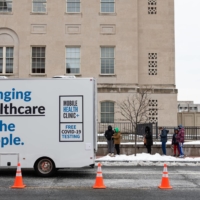 Residents stand in line to drop off COVID-19 PCR tests at a testing site run by the CDC, FEMA and eTrueNorth in Washington, D.C., on Wednesday. | BLOOMBERG