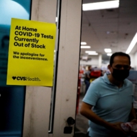 A sign at the entrance of a CVS pharmacy in Miami on Wednesday informs customers that COVID-19 tests are out of stock as the omicron variant continues to spread through the country. | REUTERS