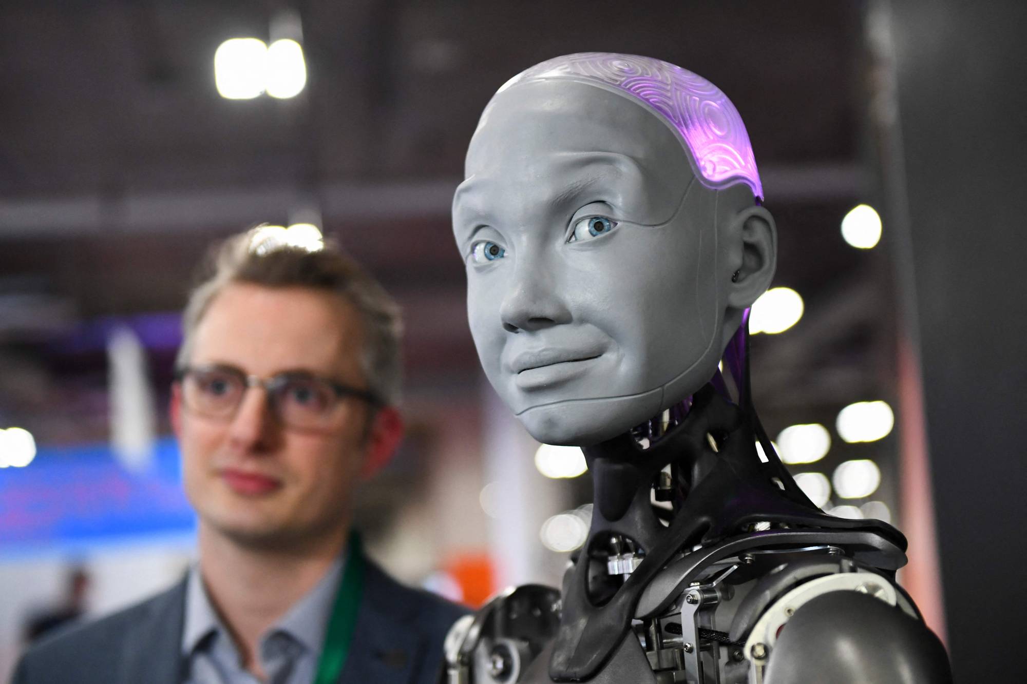 Morgan Roe, director of operations at Engineered Arts, speaks about the Engineered Arts Ameca humanoid robot during the Consumer Electronics Show on Jan. 5 in Las Vegas, Nevada. | AFP-JIJI