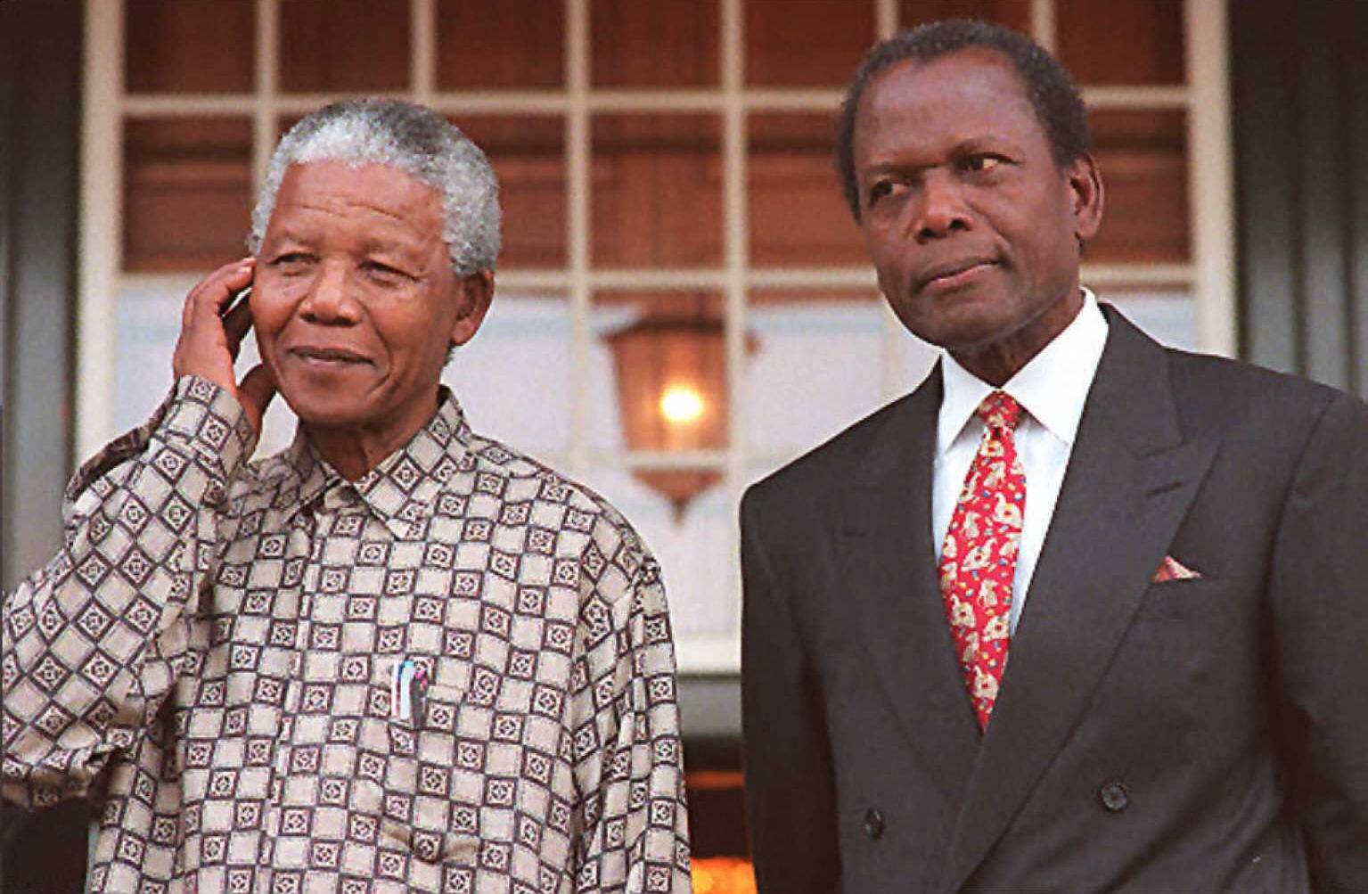 South African President Nelson Mandela and U.S. actor Sidney Poitier pose for cameras at Tuinhuis in Cape Town in May 16, 1996. | AFP-JIJI