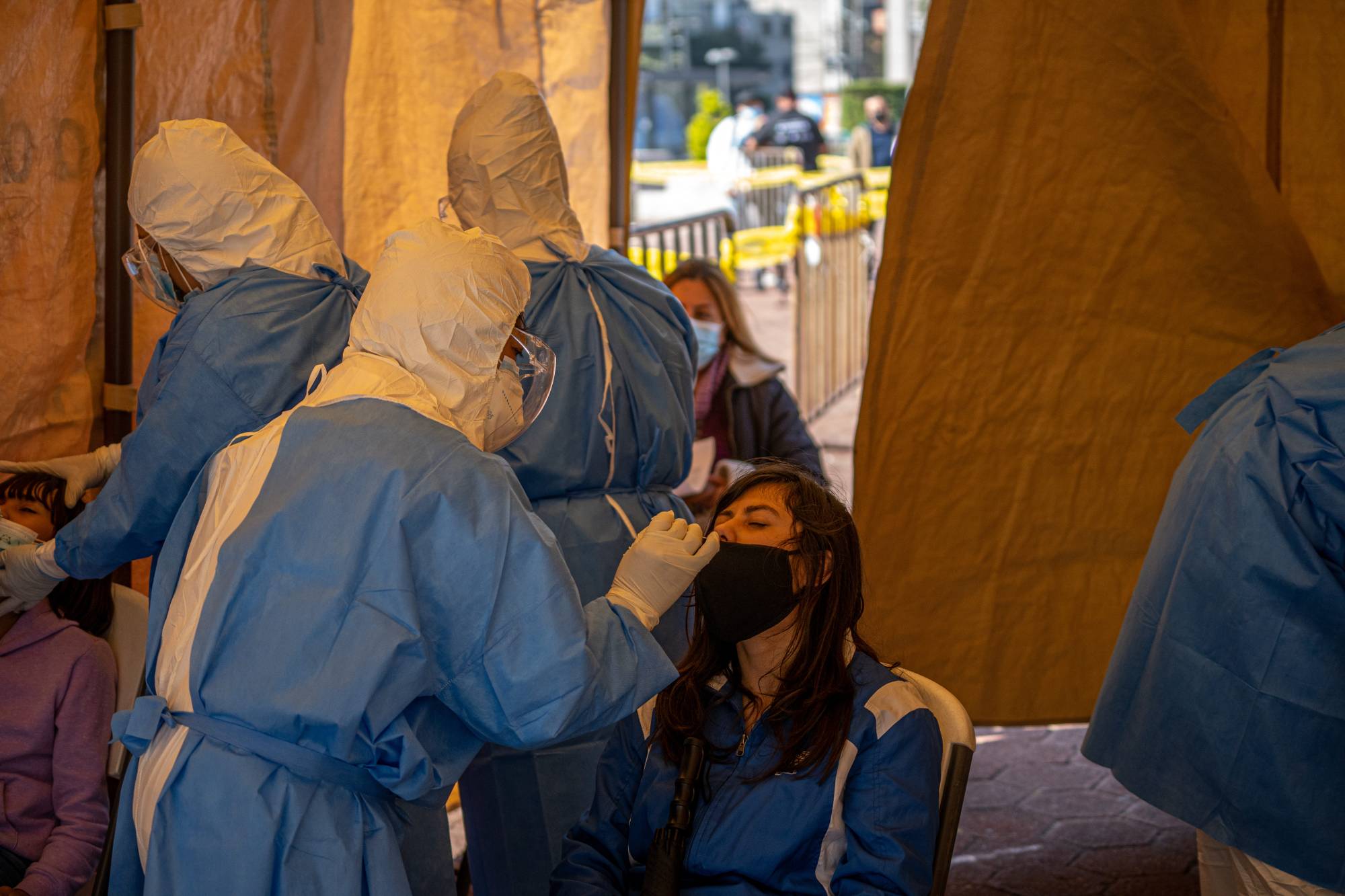 A health care worker administers a COVID-19 test at a temporary kiosk in Mexico City on Thursday. | BLOOMBERG