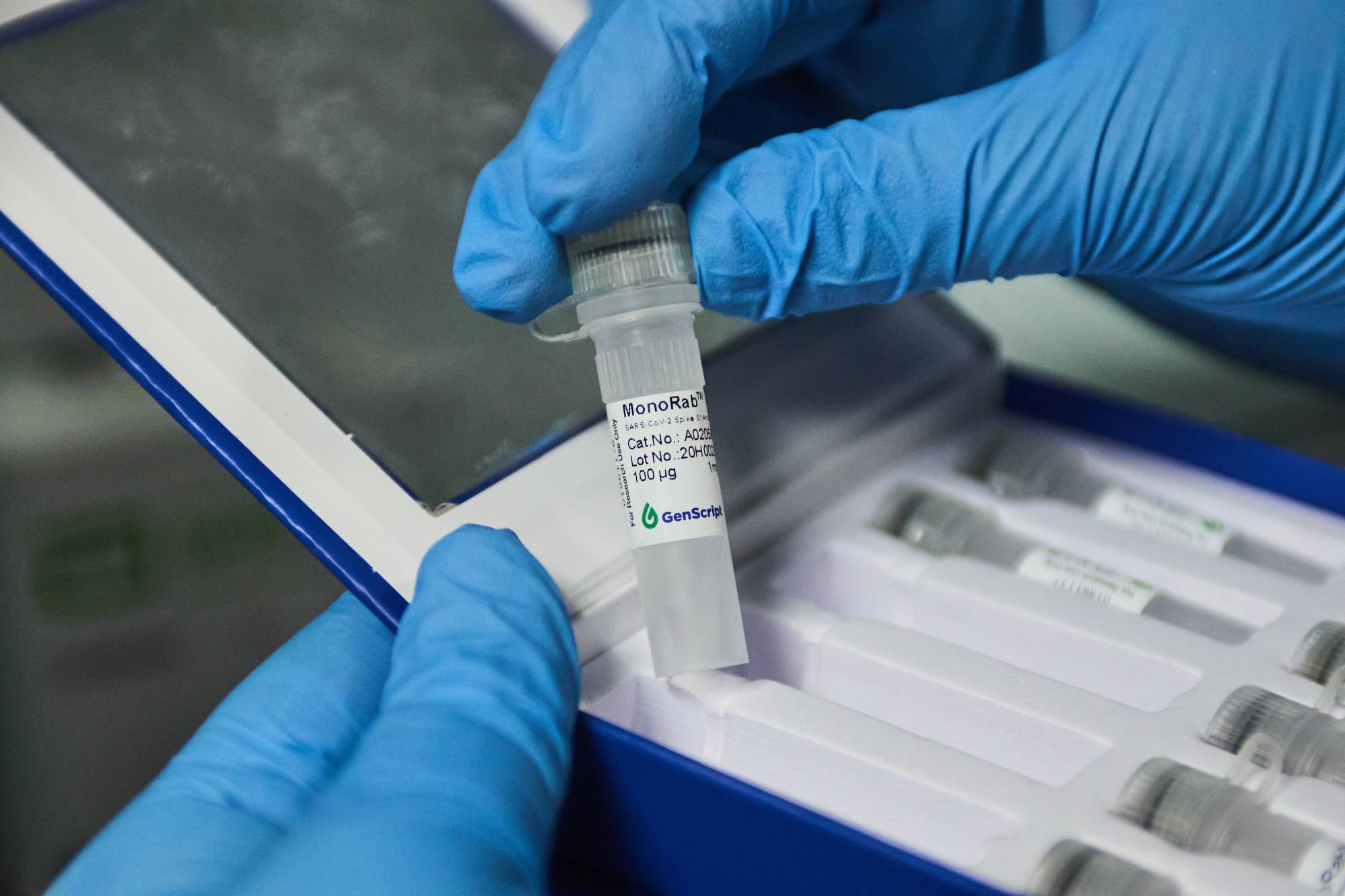 A technician handles a vial of antibody testing material in a laboratory at the African Health Research Institute in Durban, South Africa, last month. | BLOOMBERG