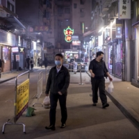 People carry bags of takeout food in Hong Kong\'s Causeway Bay area on Friday. | BLOOMBERG