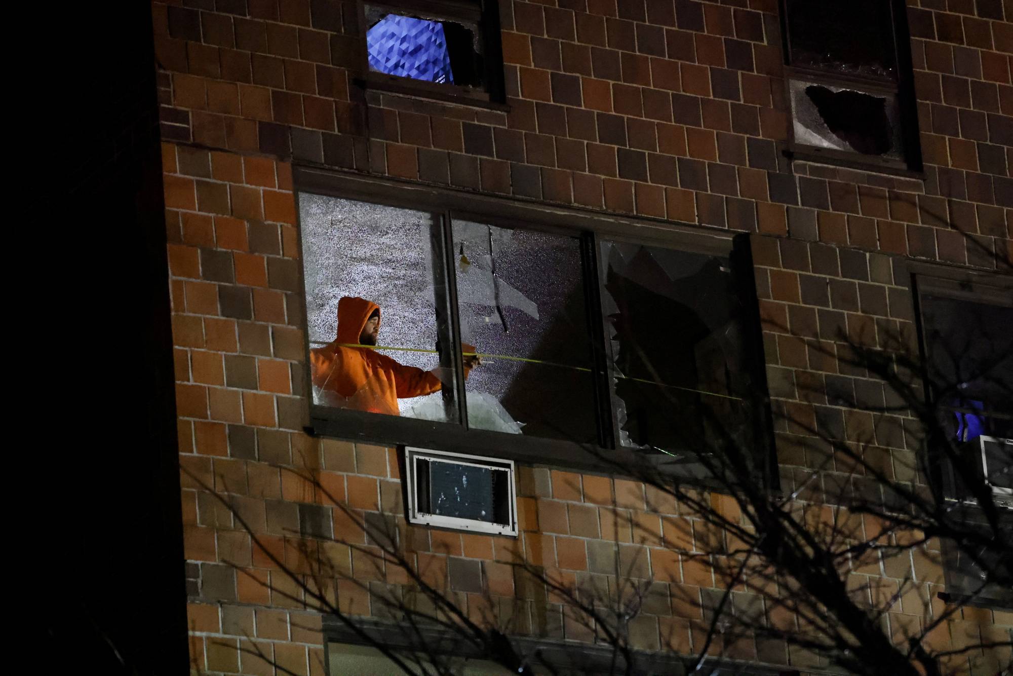 A person stands inside an apartment building where a deadly fire occurred in The Bronx borough of New York City on Sunday. | REUTERS