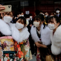 Women wearing kimonos take selfies after a Coming of Age Day celebration ceremony in Tokyo on Monday. | REUTERS