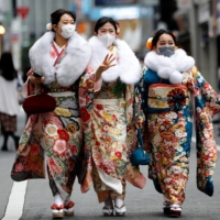 Women wearing kimonos make their way to a Coming of Age Day celebration ceremony in Tokyo on Monday. | REUTERS