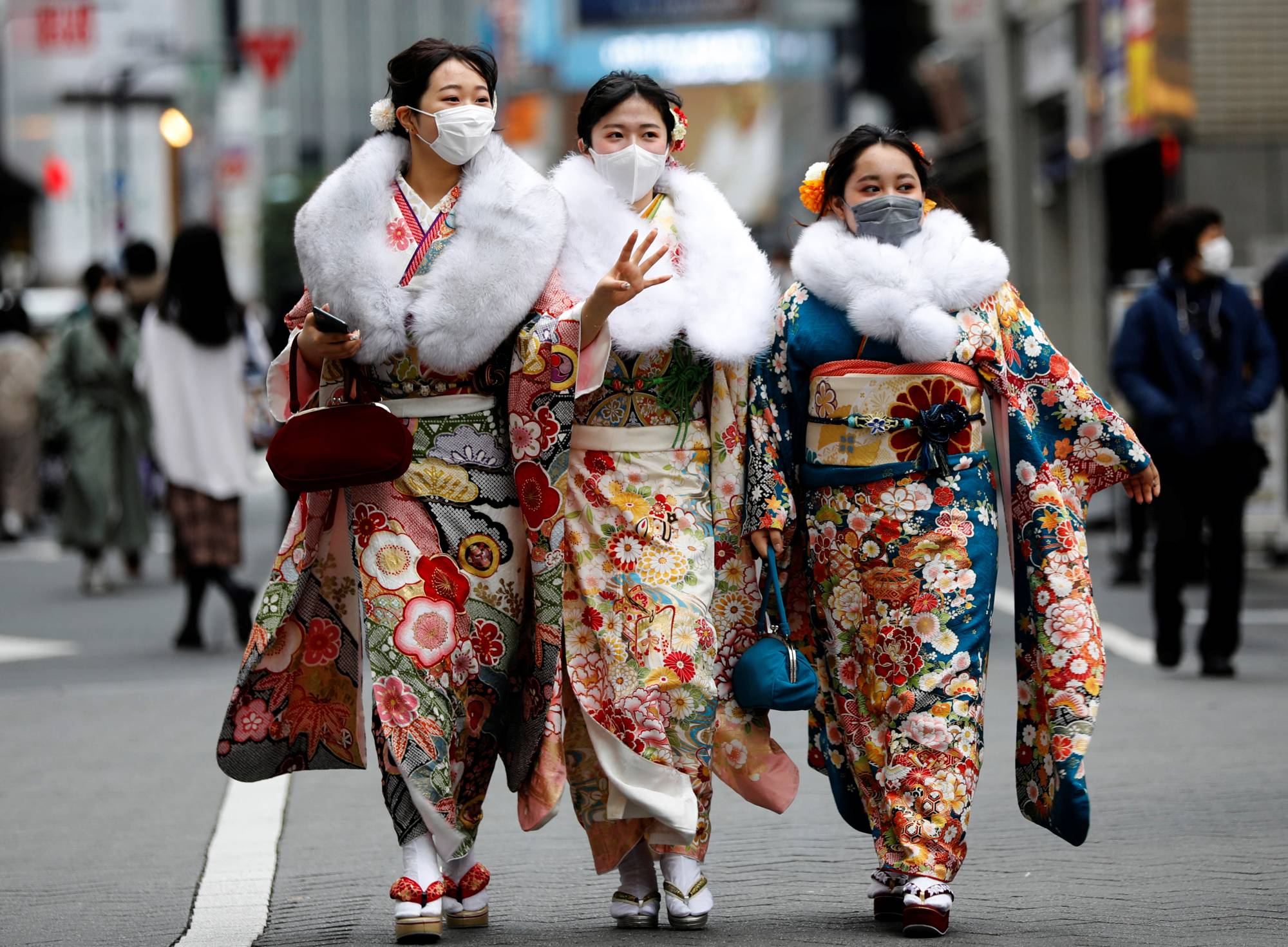 Women wearing kimonos make their way to a Coming of Age Day celebration ceremony in Tokyo on Monday. | REUTERS