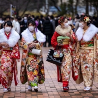Women dressed in kimonos arrive at Todoroki Arena to attend a celebration ceremony to mark Coming of Age Day in Kawasaki on Monday. | AFP-JIJI