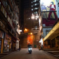 A man drives past closed bars in Hong Kong\'s Lan Kwai Fong area on Jan. 9.  | AFP-JIJI