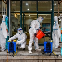 Staff members disinfect a residential area in Ningbo, in China\'s eastern Zhejiang province, on Dec. 14. | AFP-JIJI